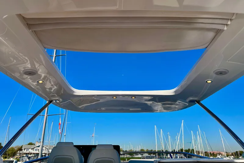  Yacht Photos Pics 2024 Azimut Fly 60 yacht with open sunroof, showcasing marina view and clear blue sky.