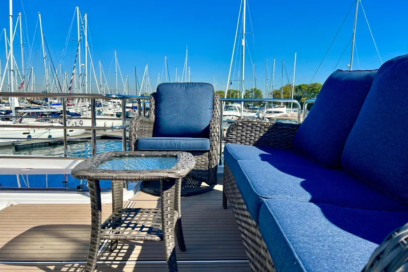  Yacht Photos Pics Outdoor seating on 2024 Azimut Fly 60 yacht, marina view, blue cushions, wicker furniture.