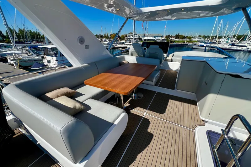  Yacht Photos Pics Luxurious 2024 Azimut Fly 60 yacht deck with elegant seating and wooden table.