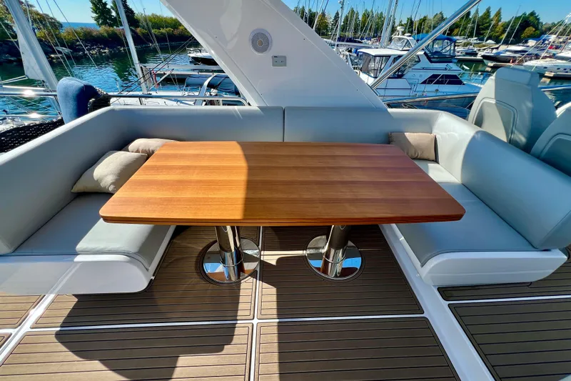 Yacht Photos Pics Luxurious seating area on 2024 Azimut Fly 60 yacht with wooden table and cushions.