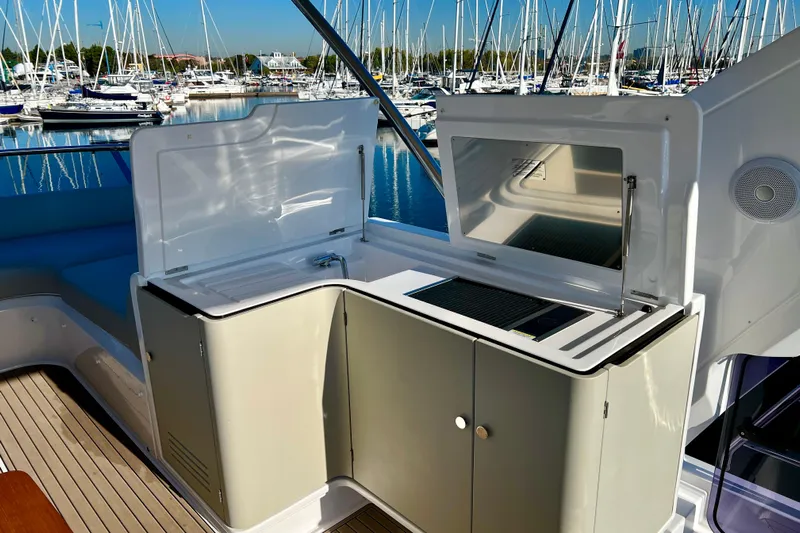  Yacht Photos Pics 2024 Azimut Fly 60 yacht kitchenette with sink and grill, docked in a marina.