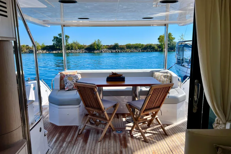  Yacht Photos Pics 2024 Azimut Fly 60 yacht deck with seating, table, and scenic water view.