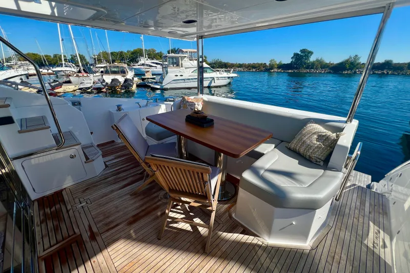  Yacht Photos Pics Luxurious 2024 Azimut Fly 60 yacht deck with seating, table, and marina view.