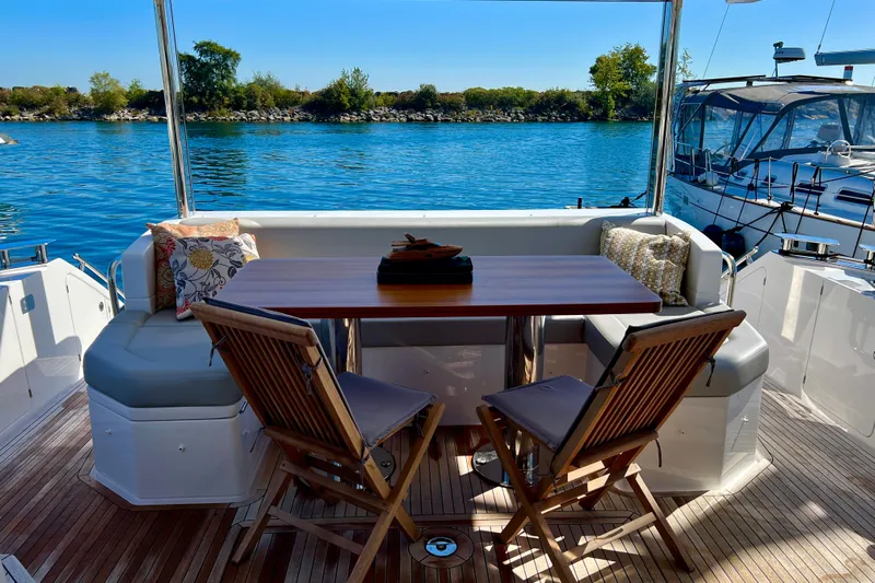  Yacht Photos Pics Luxurious 2024 Azimut Fly 60 yacht deck with seating, table, and scenic water view.