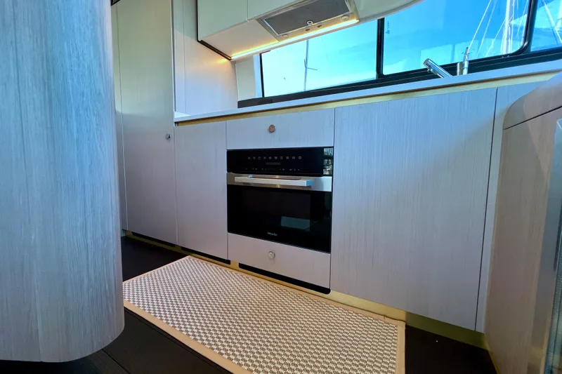  Yacht Photos Pics Modern kitchen interior of 2024 Azimut Fly 60 yacht with sleek cabinetry and appliances.