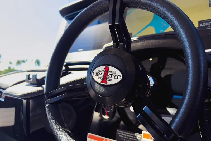  Yacht Photos Pics Steering wheel of 2025 Cigarette 41 Nighthawk boat, featuring branded emblem.