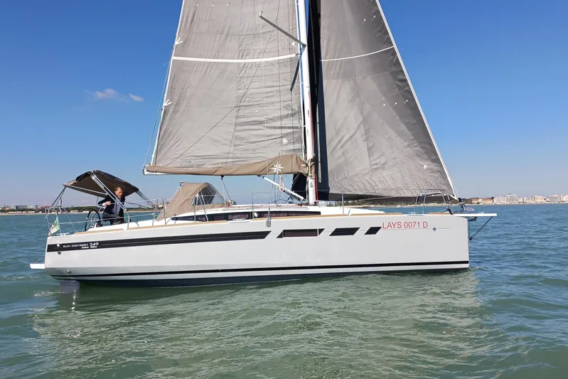 Prima Yacht Photos Pics 2024 Jeanneau Sun Odyssey 349 sailing on calm waters under clear blue skies.