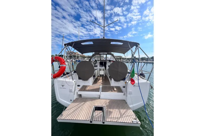 Prima Yacht Photos Pics 2024 Jeanneau Sun Odyssey 349 sailboat, rear view, docked under a blue sky.