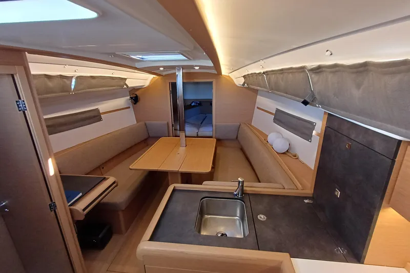 Prima Yacht Photos Pics 2024 Jeanneau Sun Odyssey 349 interior with modern kitchen and cozy seating area.