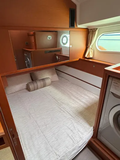 First Mates Yacht Photos Pics Interior of 2015 Beneteau Swift Trawler 44 with cozy bed and porthole window.