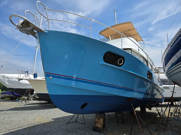 First Mates Yacht Photos Pics 2015 Beneteau Swift Trawler 44 in dry dock, vibrant blue hull, side view.