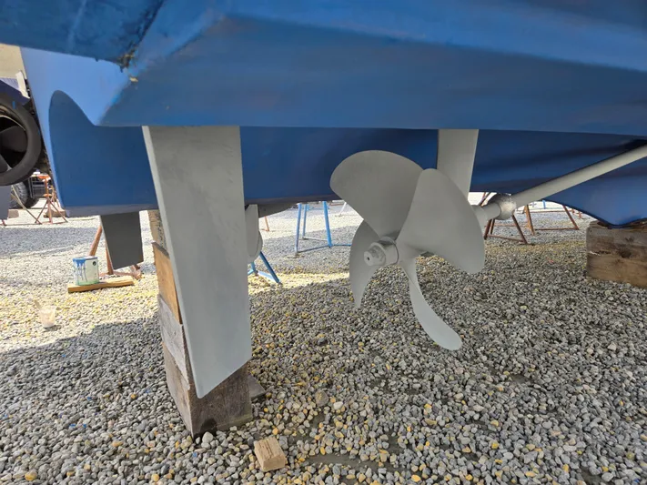 First Mates Yacht Photos Pics Propeller and hull of 2015 Beneteau Swift Trawler 44 on gravel surface.