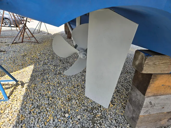 First Mates Yacht Photos Pics Propeller and rudder of 2015 Beneteau Swift Trawler 44 on gravel surface.