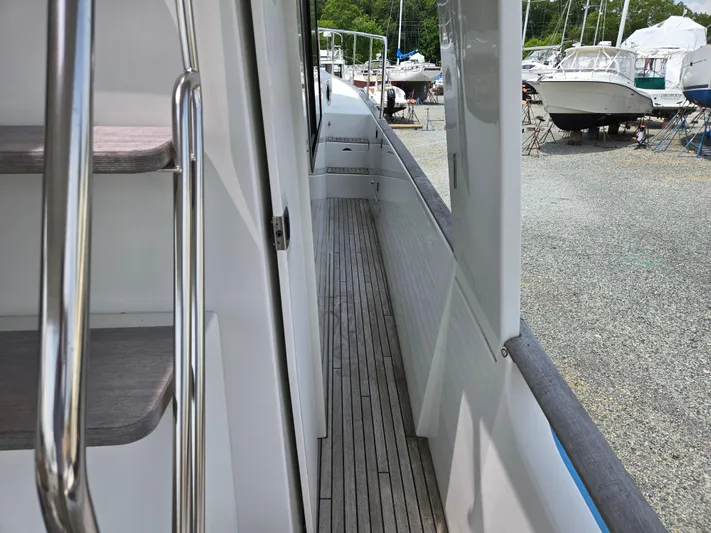 First Mates Yacht Photos Pics 2015 Beneteau Swift Trawler 44 side deck with wooden flooring and railing.