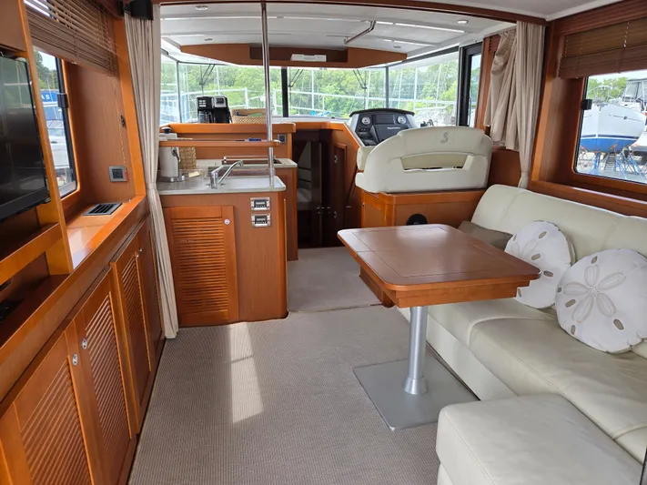 First Mates Yacht Photos Pics Interior of 2015 Beneteau Swift Trawler 44, featuring a cozy seating area and kitchenette.
