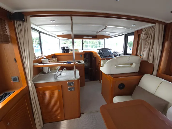 First Mates Yacht Photos Pics Interior of 2015 Beneteau Swift Trawler 44, featuring kitchen and seating area.