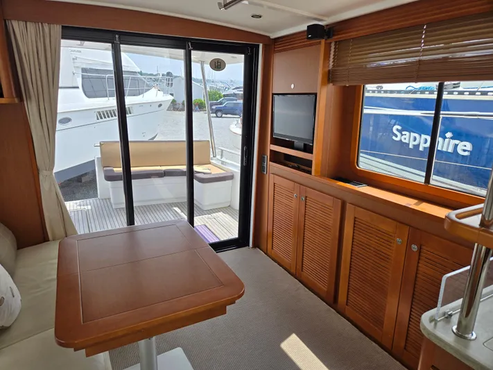 First Mates Yacht Photos Pics Interior of 2015 Beneteau Swift Trawler 44 with wooden furnishings and outdoor view.