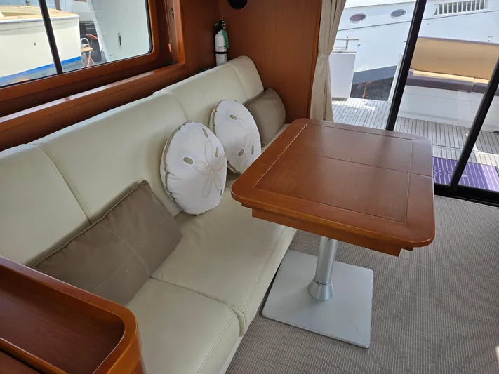 First Mates Yacht Photos Pics Interior of 2015 Beneteau Swift Trawler 44 with cozy seating and wooden table.