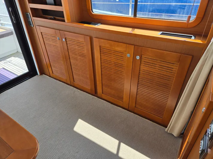 First Mates Yacht Photos Pics Interior of 2015 Beneteau Swift Trawler 44 with wooden cabinets and carpeted floor.