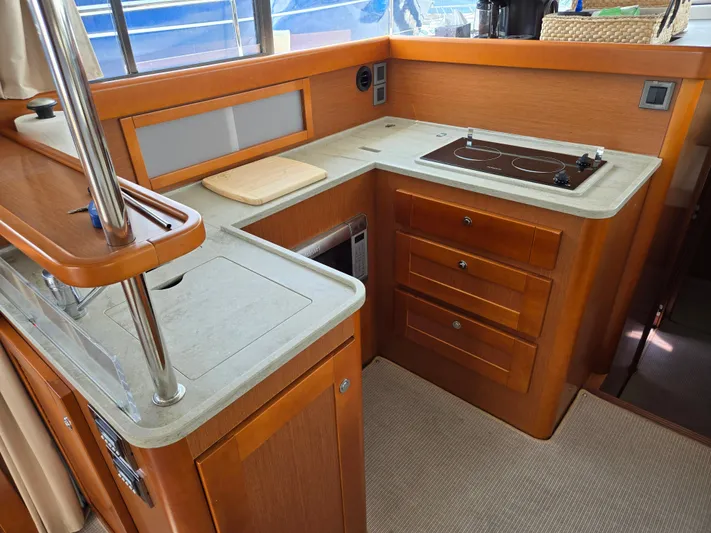 First Mates Yacht Photos Pics 2015 Beneteau Swift Trawler 44 kitchen with wooden cabinetry and modern appliances.
