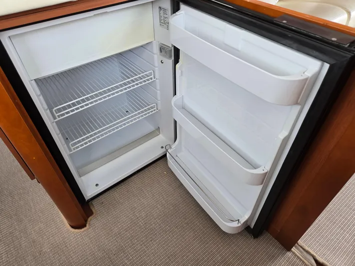 First Mates Yacht Photos Pics Open refrigerator inside a 2015 Beneteau Swift Trawler 44, showing empty shelves and door compartments.