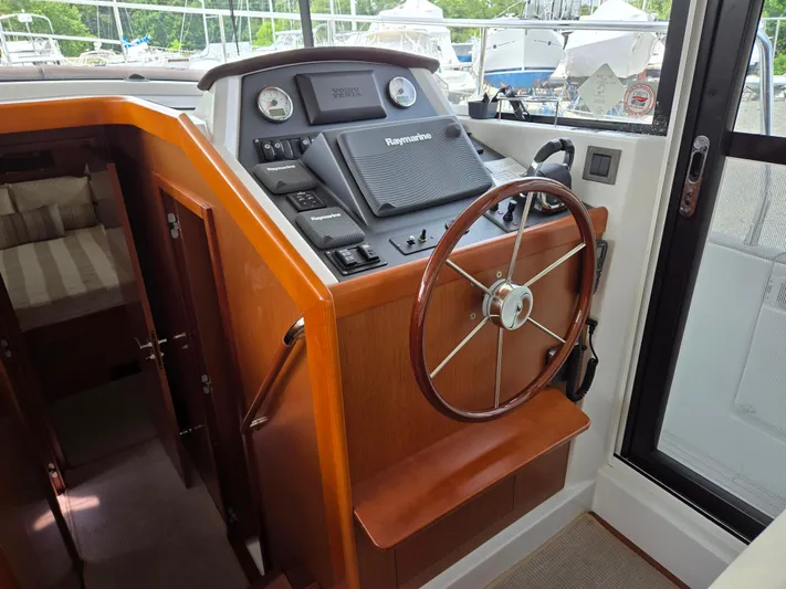 First Mates Yacht Photos Pics 2015 Beneteau Swift Trawler 44 helm with wooden wheel and navigation equipment.