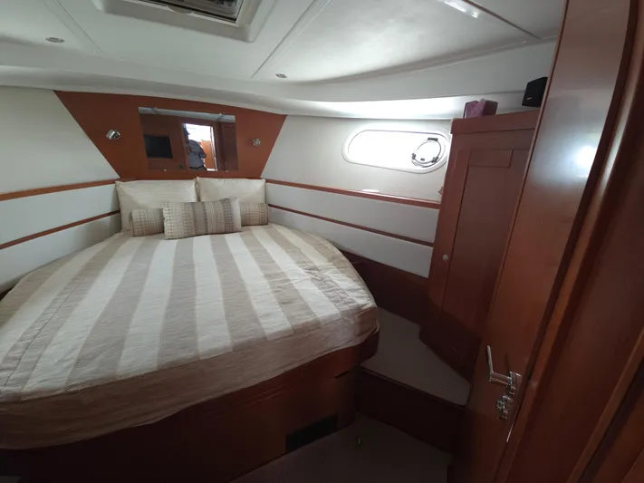 First Mates Yacht Photos Pics Cozy bedroom in 2015 Beneteau Swift Trawler 44 with striped bedding and wooden accents.