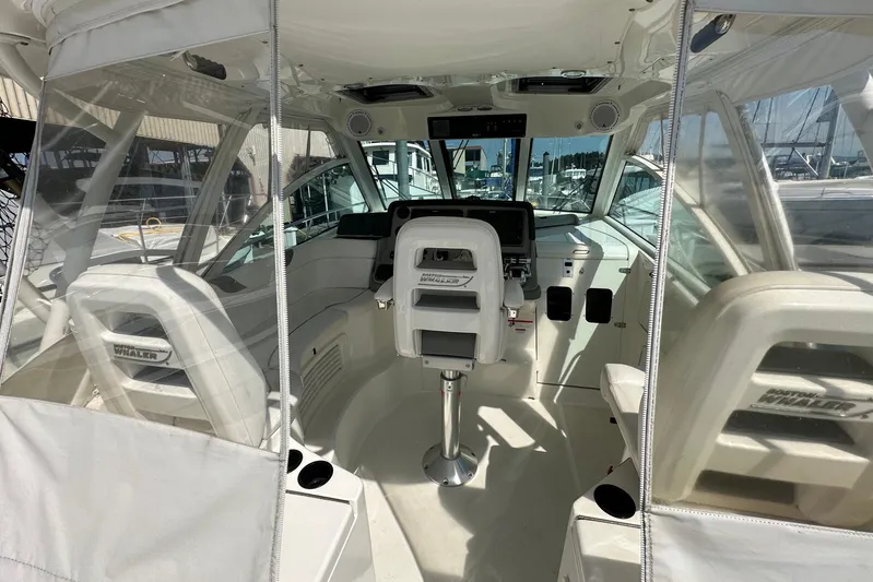  Yacht Photos Pics 2013 Boston Whaler 345 Conquest cockpit with helm, seating, and clear enclosure.