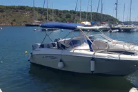 2007 Quicksilver 600 Commander boat docked in a scenic marina with sailboats.