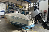2007 Quicksilver 600 Commander boat in a workshop, featuring an outboard motor.