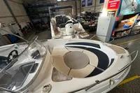 2007 Quicksilver 600 Commander boat in a workshop, showcasing seating and control area.