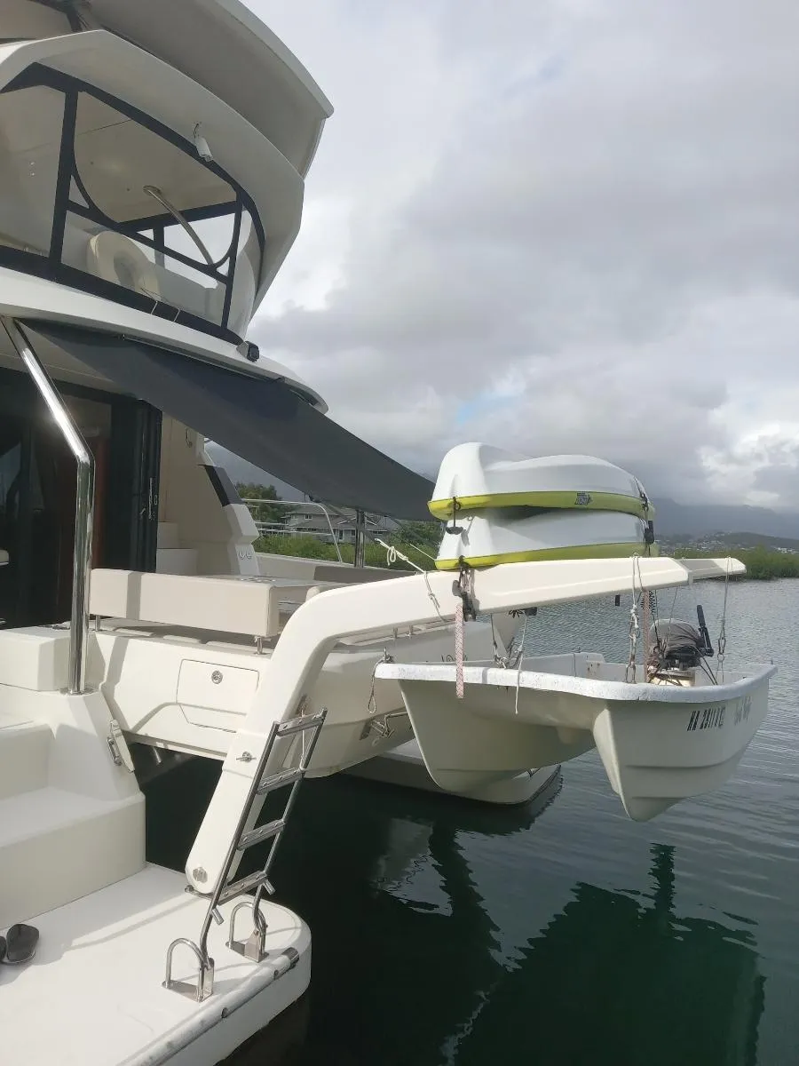 Aquila 44 yacht, 2016 model, docked with a small boat on davits.