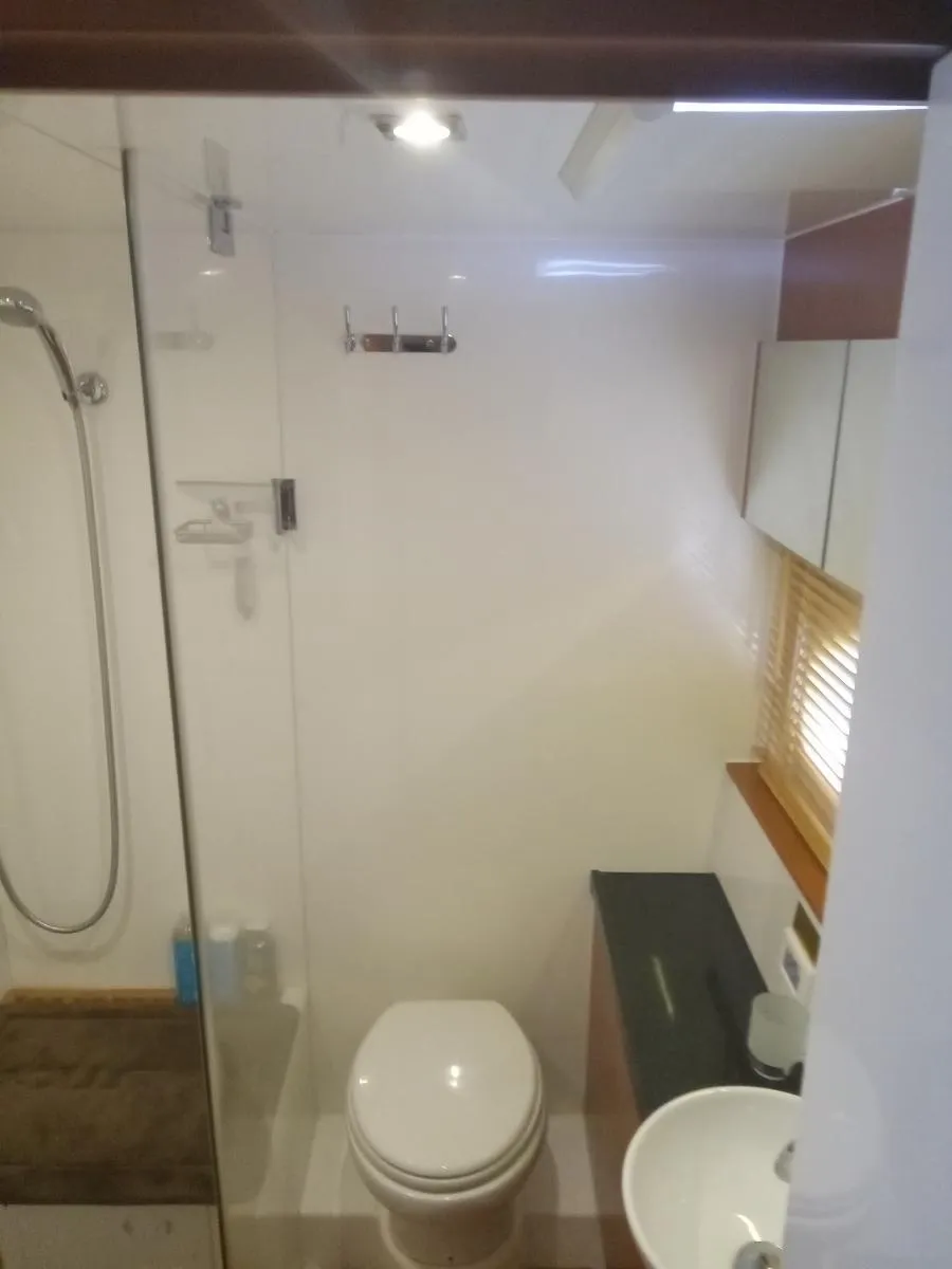 Modern bathroom in 2016 Aquila 44 yacht with shower, toilet, and sink.