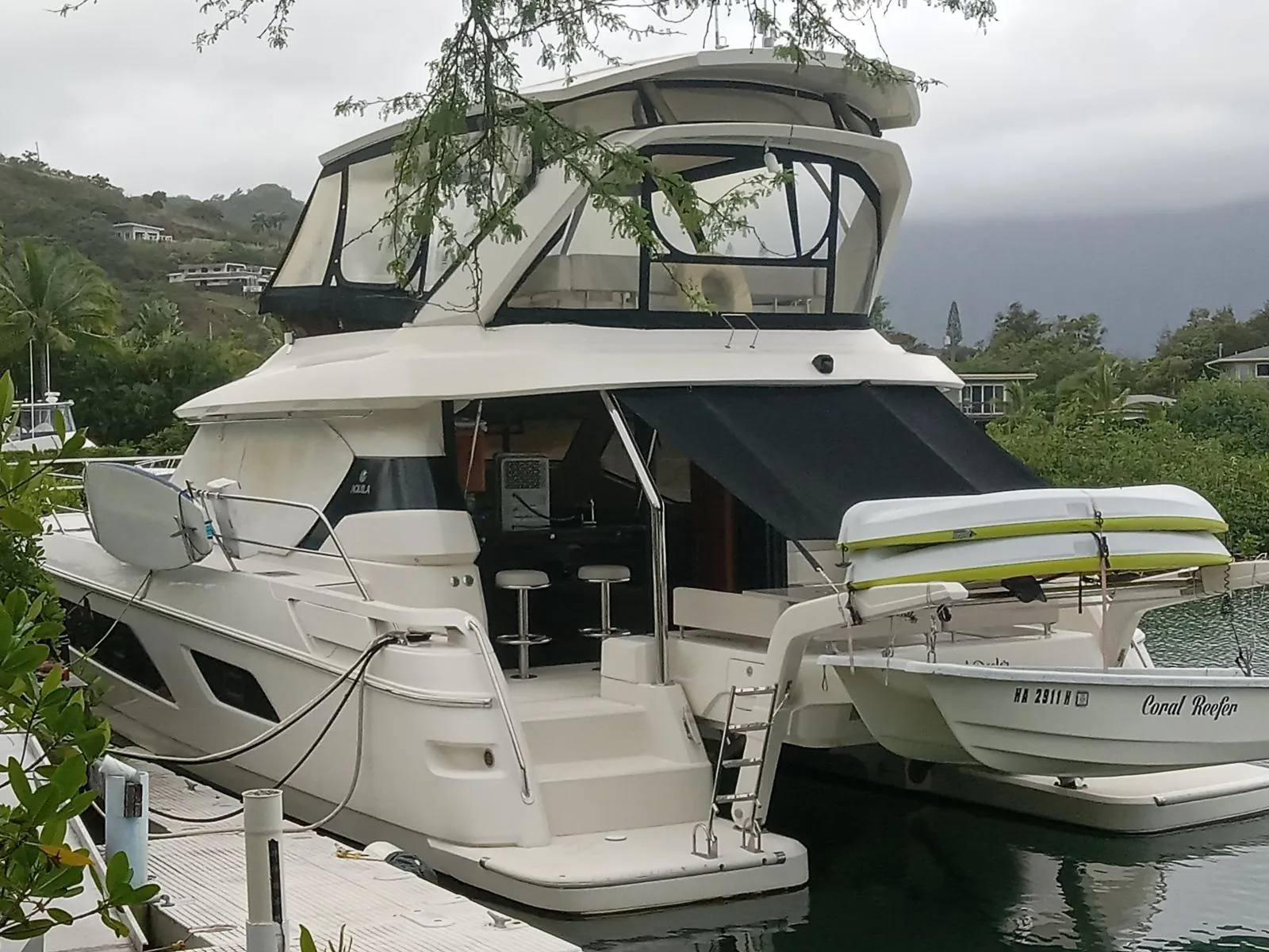 Luxury 2016 Aquila 44 yacht docked in a scenic marina setting.
