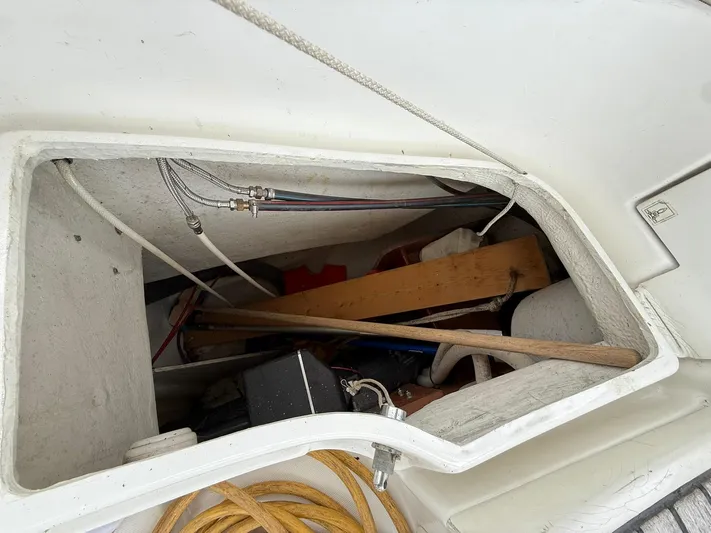 French Angel Yacht Photos Pics Storage compartment of a 2003 Beneteau 393 sailboat with various tools and equipment.