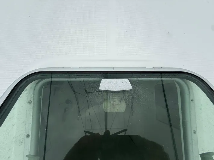 French Angel Yacht Photos Pics Close-up of a 2003 Beneteau 393 boat window with visible reflections.