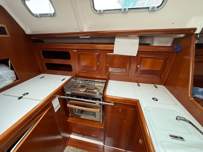French Angel Yacht Photos Pics 2003 Beneteau 393 yacht kitchen with wood cabinetry and built-in stove.