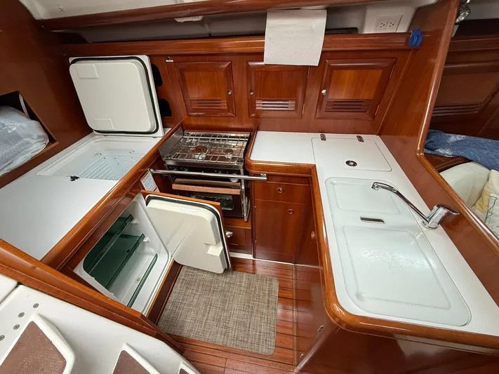 French Angel Yacht Photos Pics 2003 Beneteau 393 yacht kitchen with stove, sink, and refrigerator.