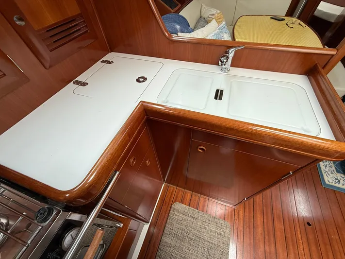 French Angel Yacht Photos Pics 2003 Beneteau 393 yacht kitchen with wooden cabinetry and dual sink.