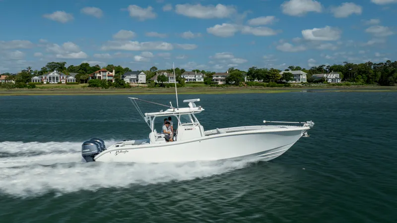 Yacht Photos Pics 2019 Yellowfin 36 boat cruising on water with coastal homes in the background.