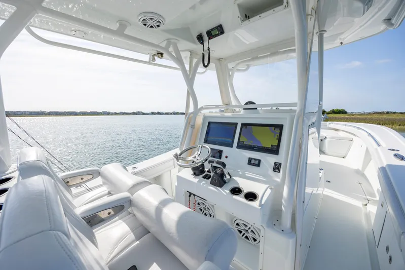  Yacht Photos Pics 2019 Yellowfin 36 boat cockpit with dual screens and steering wheel, overlooking calm waters.