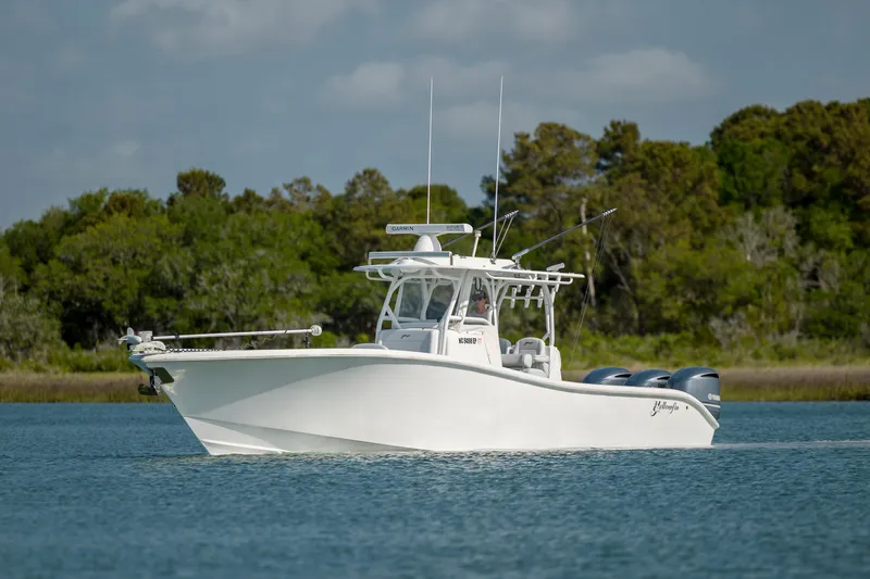  Yacht Photos Pics 2019 Yellowfin 36 boat on calm water with lush green trees in the background.