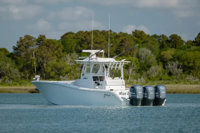  Yacht Photos Pics 2019 Yellowfin 36 boat with triple outboard engines on a calm lake.