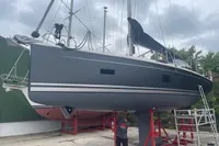 2023 Hanse 388 sailboat on stands, gray hull, overcast sky, person working below.
