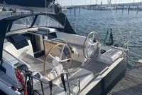 2023 Hanse 388 sailboat docked, featuring dual steering wheels and sleek deck design.