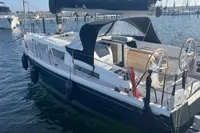 2023 Hanse 388 sailboat docked in marina, featuring dual steering wheels and sleek design.