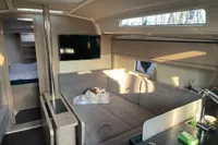 Modern interior of 2023 Hanse 388 yacht with cozy seating and TV.