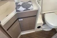 2023 Hanse 388 yacht bathroom with modern fixtures, wooden cabinetry, and striped towel.