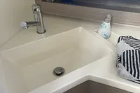 Modern bathroom sink in 2023 Hanse 388 yacht with faucet and striped towel.