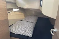 Cozy cabin interior of 2023 Hanse 388 yacht with striped bedding.